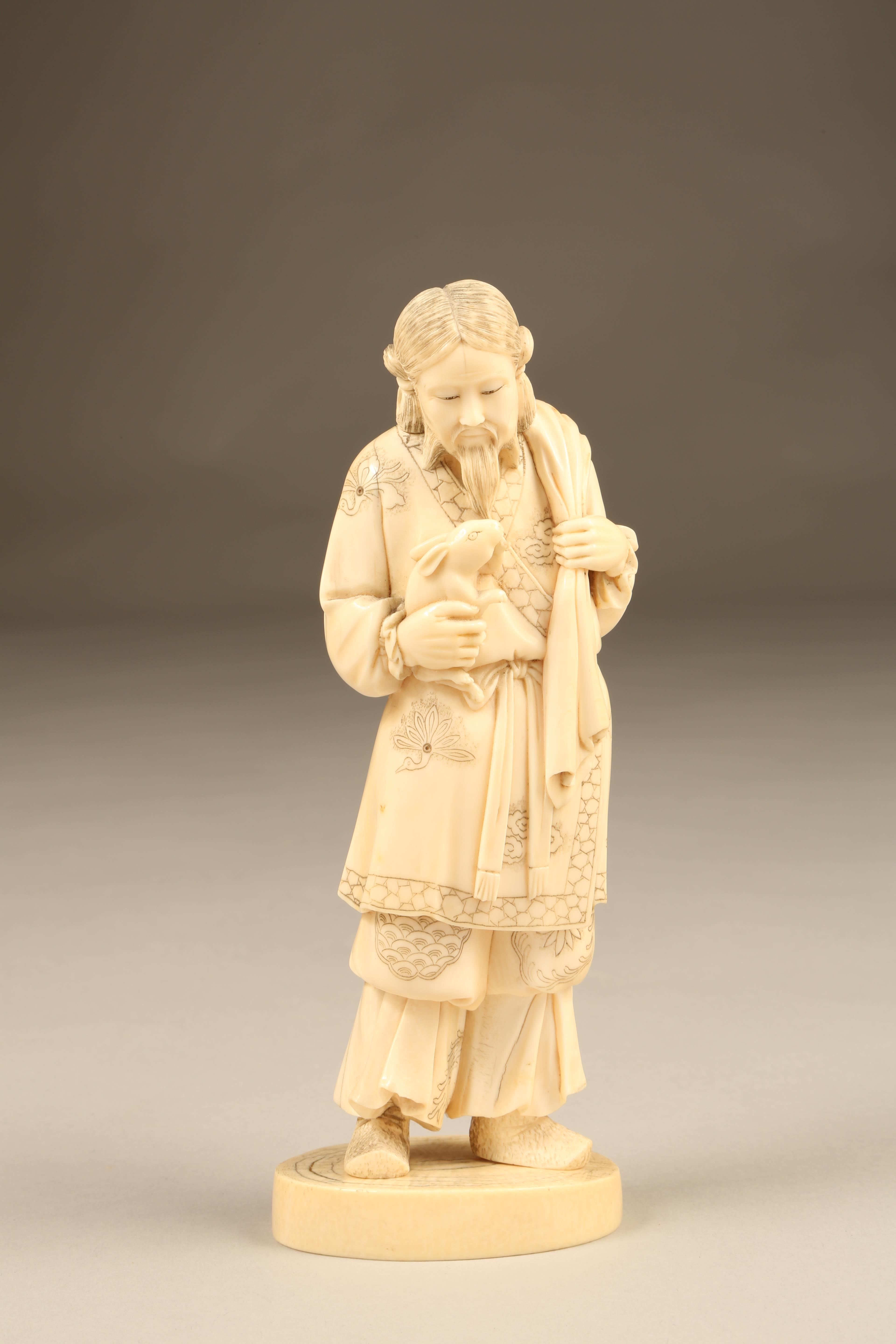 Japanese carved ivory figure, a man holding a rabbit signed to base, Meiji period. 19.5cm high