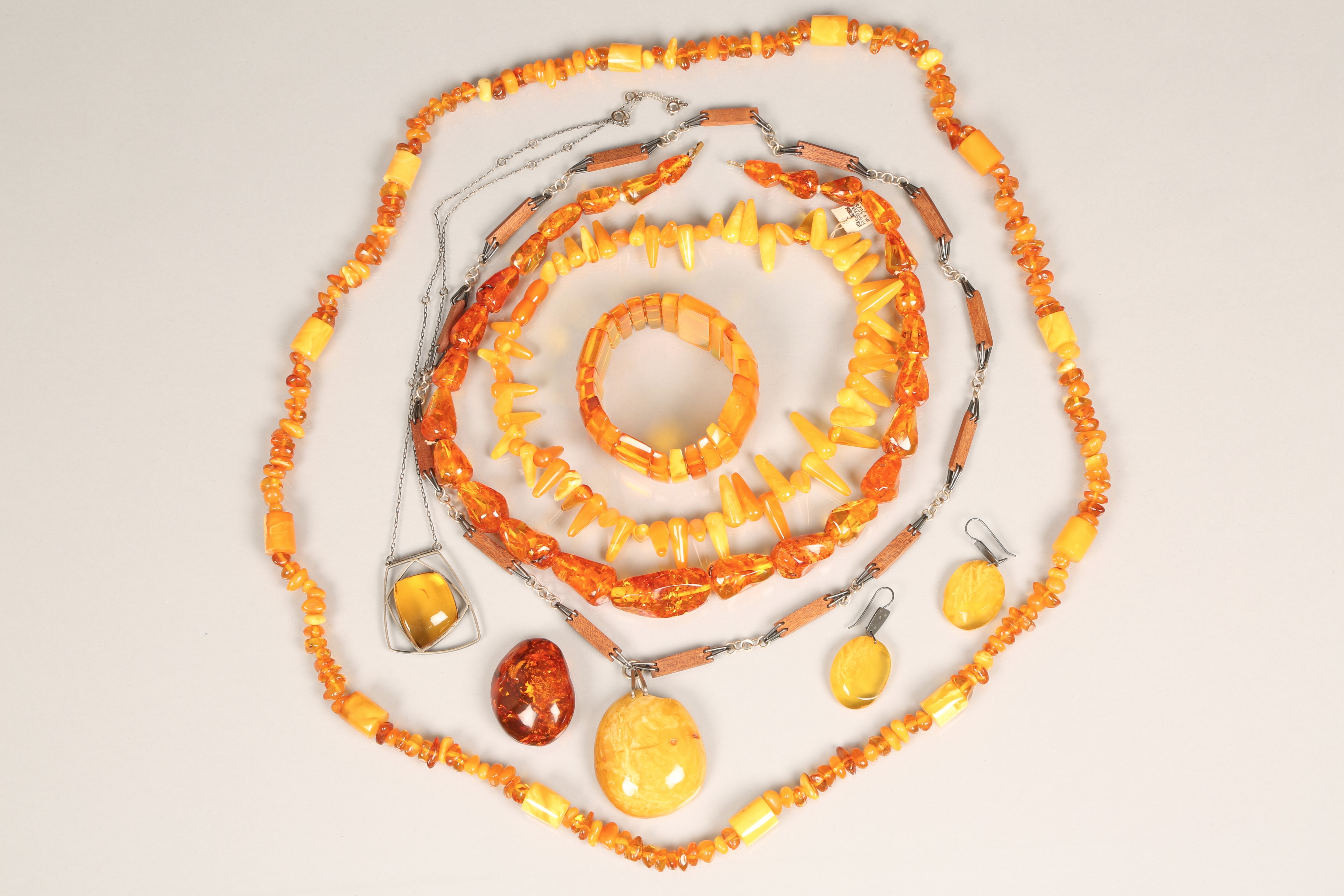 Group of assorted Baltic amber jewellery, including; three strings of amber, a pendant and earring