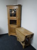 A blonde oak corner display cabinet together with a similar drop leaf coffee table