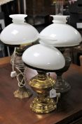 Two brass oil lamps with shades together with one other