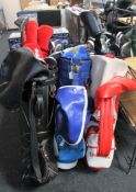 Three golf bags containing assorted clubs including a set of Wilson Cobra irons,