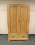 A late Victorian pine double wardrobe fitted with a drawer,