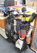 Three golf bags containing a quantity of assorted drivers