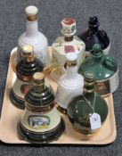A tray containing eight china whisky decanters