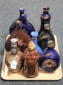 A tray containing nine china decanters including Dimple whisky,