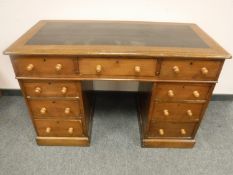 A Victorian oak pedestal desk fitted with nine drawers, width 121 cm.