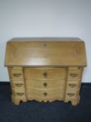 An early 20th century continental oak serpentine fronted bureau
