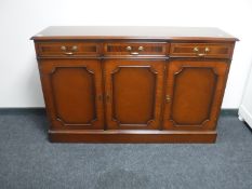 An inlaid mahogany Regency style triple door sideboard