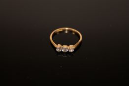 An 18ct gold three stone diamond ring, size M.