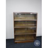 A mid 20th century four tier stacking glazed door bookcase