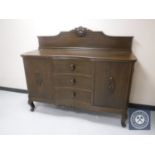 An early 20th century oak serpentine fronted sideboard