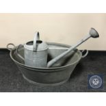 A galvanised twin handled wash tub with watering can