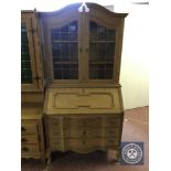 A blonde oak bureau bookcase with leaded glass doors