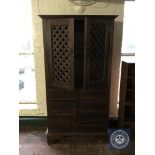 A hardwood double door cabinet fitted with eight drawers beneath