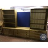 A blonde oak twin section bookcase fitted with cupboards beneath together with a similar four