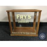 A vintage glass display cabinet with later 'Frys' advertising.