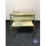 A nest of three brass and onyx tables