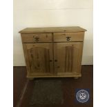 A pine double door sideboard fitted with two drawers