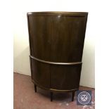 A mid twentieth century walnut double door bowfront corner cabinet