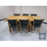 A blonde oak refectory dining table with extension leaves together with six chairs upholstered in