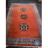 A fringed Oriental carpet on red ground,