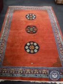 A fringed Oriental carpet on red ground,