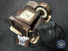 A tray of cased binoculars, leather cased camera together with a Smiths clock,