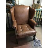 A twentieth century tan leather wing backed armchair