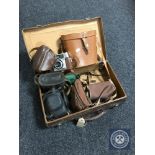 A vintage leather luggage case containing a set of Regent 10 x 50 binoculars,