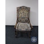 A continental oak scroll arm armchair upholstered in a tapestry fabric