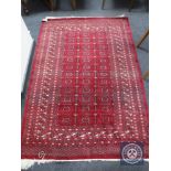 A fringed Afghan Tekke rug on red ground,