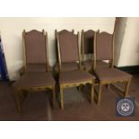 A set of six blonde oak high backed dining chairs upholstered in purple fabric