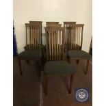 A set of seven teak rail backed dining chairs