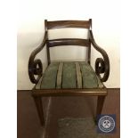 An antique mahogany scroll arm armchair