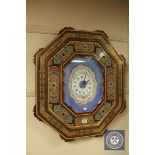 A highly ornate wall clock in a decorative frame with quartz movement, 63 cm x 73 cm.