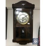 A 20th century oak wall clock with silvered dial plus pendulum and weights