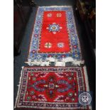 Two fringed woollen rugs on red ground