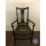 An antique inlaid mahogany bergere seated armchair