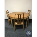 A Nathan teak display unit together with circular dining table and three chairs