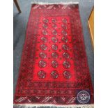 A fringed Afghan Bokhara rug on red ground,