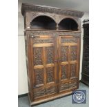 A 19th century carved oak double door cabinet fitted with two drawers, width 144 cm.