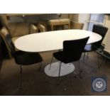 An oval contemporary white pedestal dining table together with a set of three black leather chairs