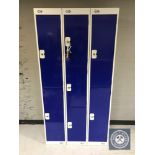 A triple section metal locker with seven compartments with keys