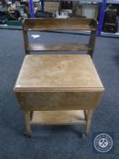 A mid 20th century two tier flap sided tea trolley together with a set of bookshelves