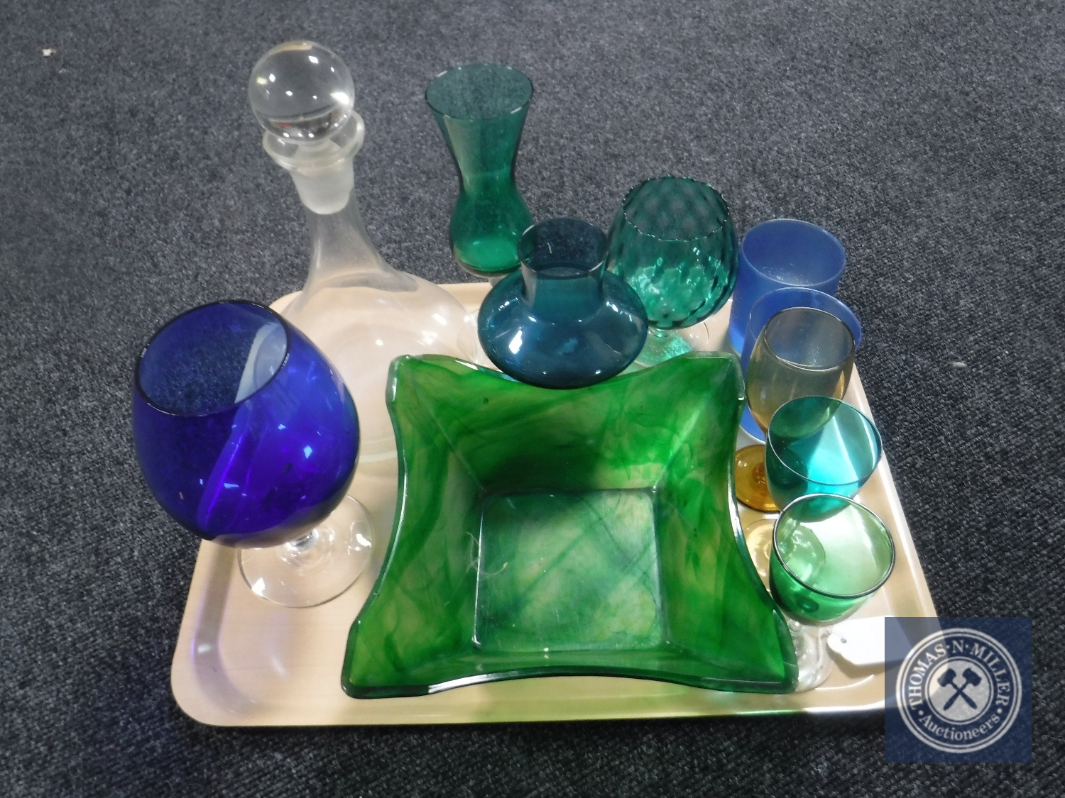 A tray containing a collection of 20th century coloured glass, decanter with stopper,