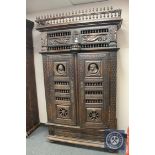A 19th century carved oak double door cabinet fitted with a drawer,