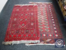 Two Eastern fringed rugs on red ground