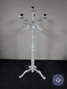 A cast iron four-way floor lamp on tripod stand