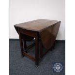 An oak gate leg table and an occasional table