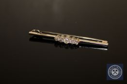 An 18ct white gold and platinum set five stone diamond bar brooch, approximately 0.7ct, 5.2g.